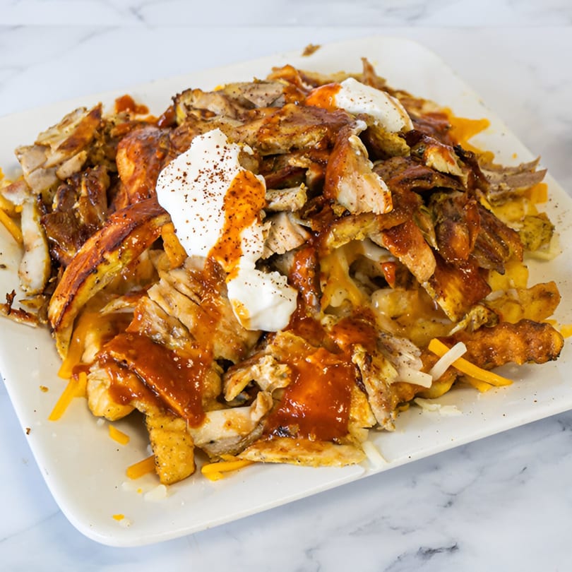 Shawarma Azmi's chicken shawarma poutine with gravy, cheese curds, and a dollop of white sauce.
